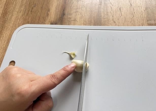 にんにくの両端を切り落とす(▶次へ)