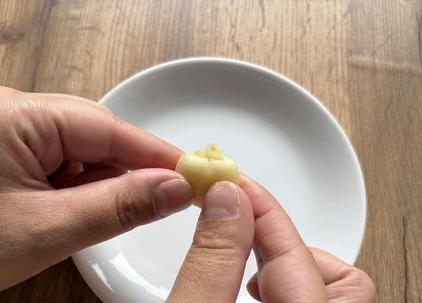 にんにくを押すと、芽の先端が断面からにゅっと出てくる(▶次へ)