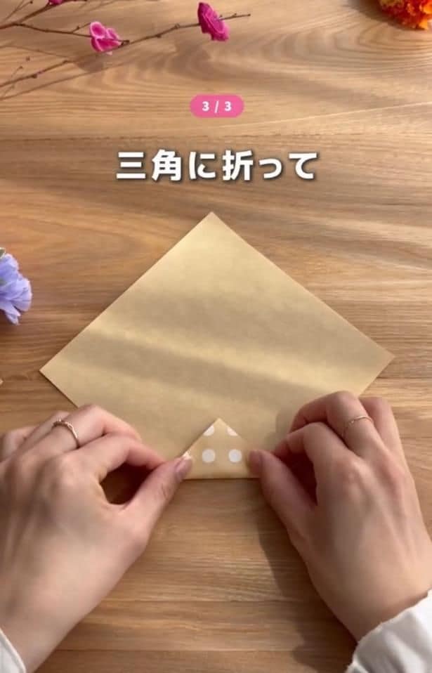 折り紙の下の角を小さい三角に折る▶続いて左右を折り…（⇒次へ）