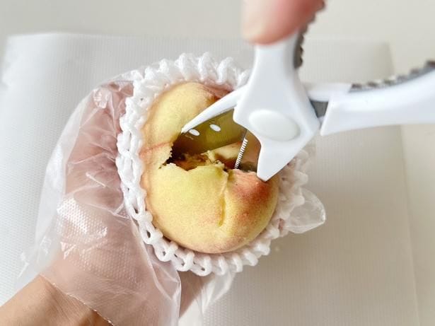キッチンバサミを左右に揺らしながら、種と果肉を離します（▶次へ）