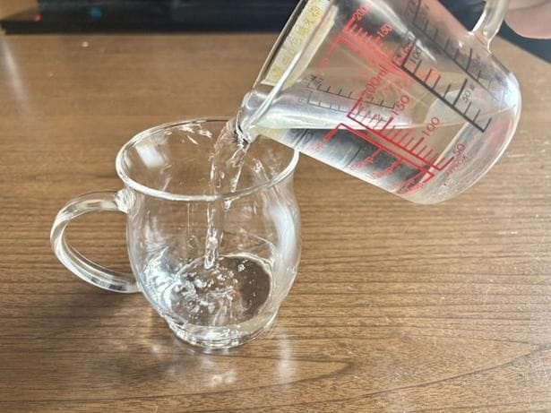 耐熱マグカップに水を入れます（▶次へ）