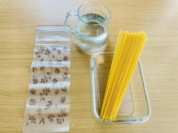 乾麺のパスタ、水、フリーザーバッグなどの容器(▶手順は?)