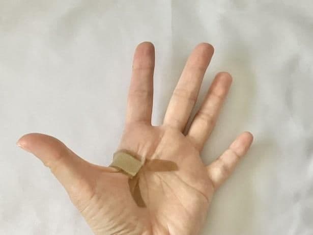 両端から切れ目を入れた粘着テープを大きく広げて貼ると…（▶次へ）