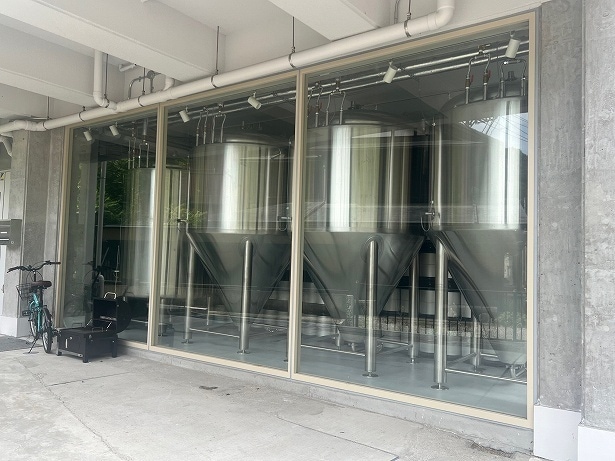 建物のビールタンクが並んでいるのがガラス窓越しに見える