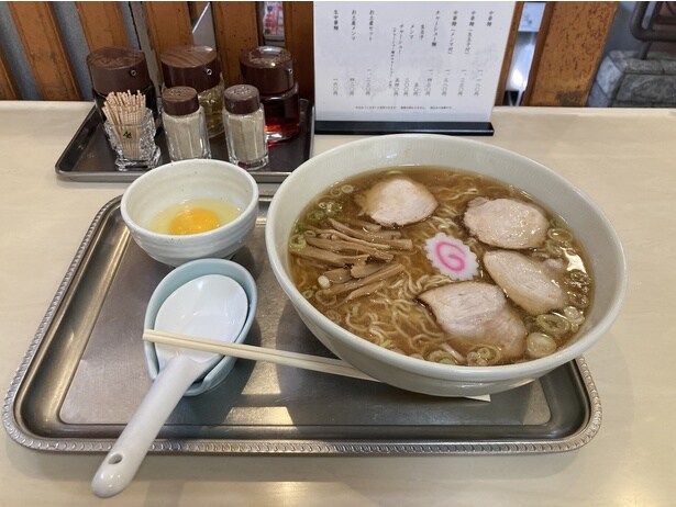 「生卵」(50円)を追加でオーダー。「中華麺」は直径約24.5cmの特大丼で提供される。レンゲも大きめサイズ