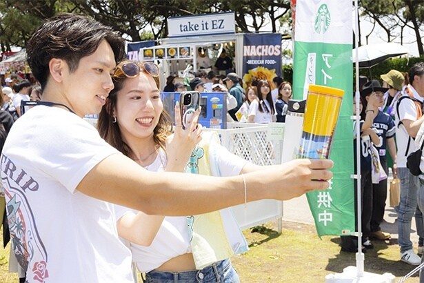 記念撮影する水野さんと石川さん。多くの来場者がフェス×タンブラーを撮影していた