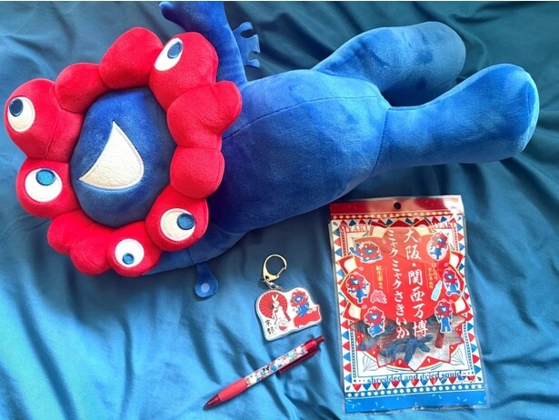大阪・関西万博でゲットした最近の愛用品とミャクミャクくじの景品。特に「ミャクミャクさきいか」は他府県の人に渡すと喜ばれた