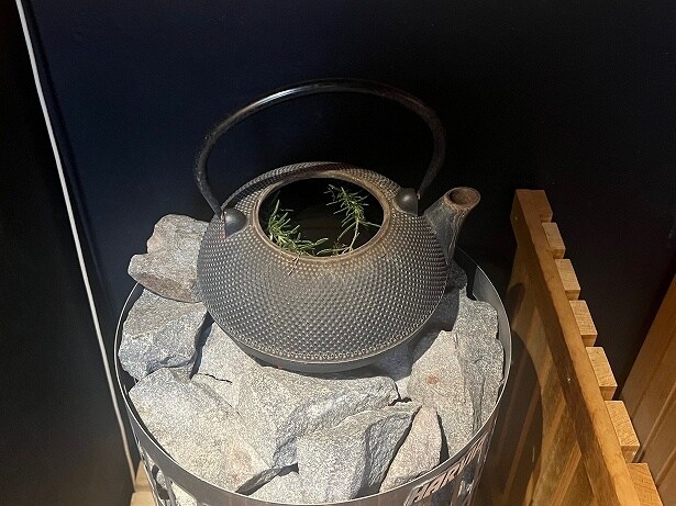 サウナストーンの上に鉄瓶が置かれていて、施設で育てたハーブが入っている