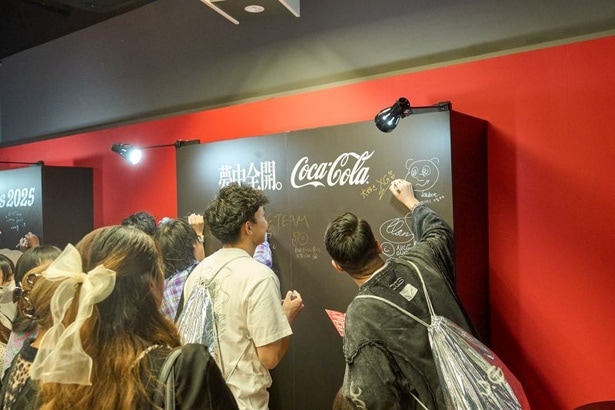 応援メッセージボード。各アーティストに向けて懸命にメッセージを書き記す来場者の姿も