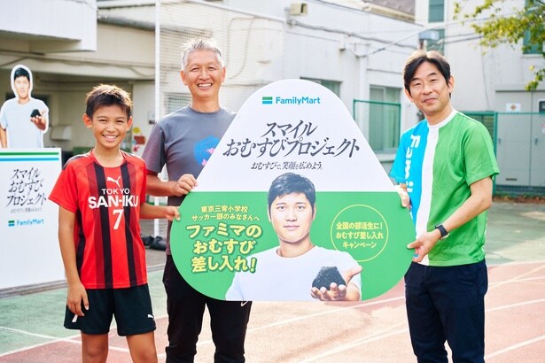 「スマイルおむすびプロジェクト」の記念パネルを受け取るキャプテンと顧問の先生