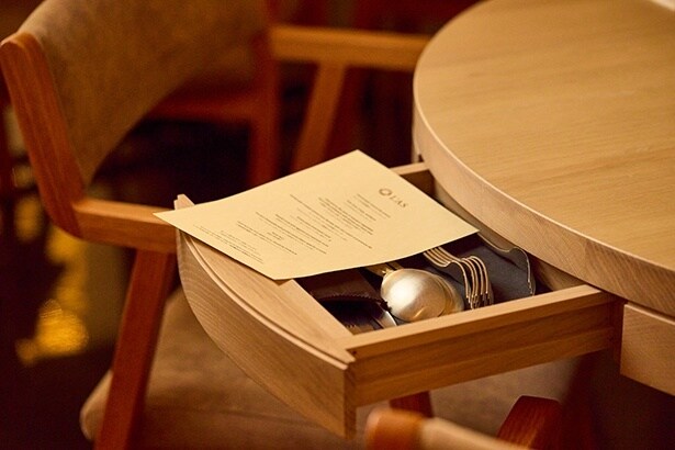 テーブルの隠し引き出しを開くとカトラリーが並ぶ。遊び心と業務の効率化を兼ね備えたアイデア