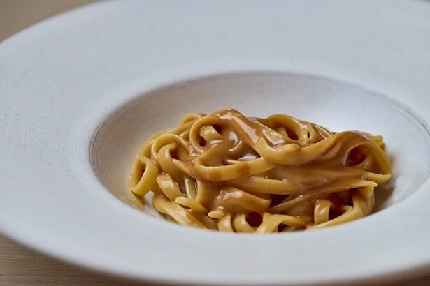 「アメリケーヌソースをシンプルに味わう一皿」。オマール海老の頭の殻で出汁をとった濃厚なソースが麺に絡む。シンプルな料理なだけにパスタは「マンチーニ」のリングイネを使用するなど、かけるべき素材への原価は惜しまない