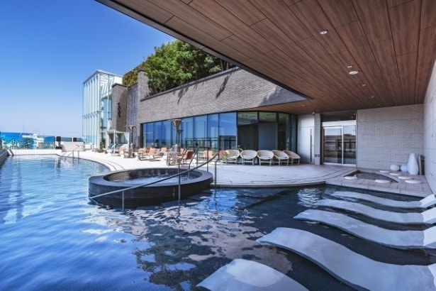 日中の温泉スパ。湯の中にチェアがあり、ゆっくり温泉につかれる