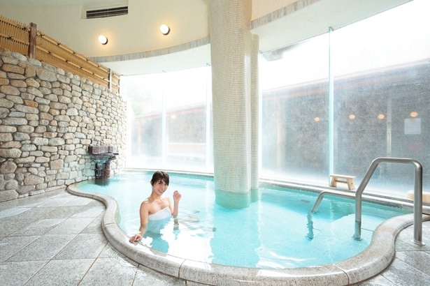 「山水閣」1階、「野天風呂」。「観音の湯」(女湯)。「ぼたんの湯」と呼ばれる内湯は、全面ガラス窓で明るい空間だ