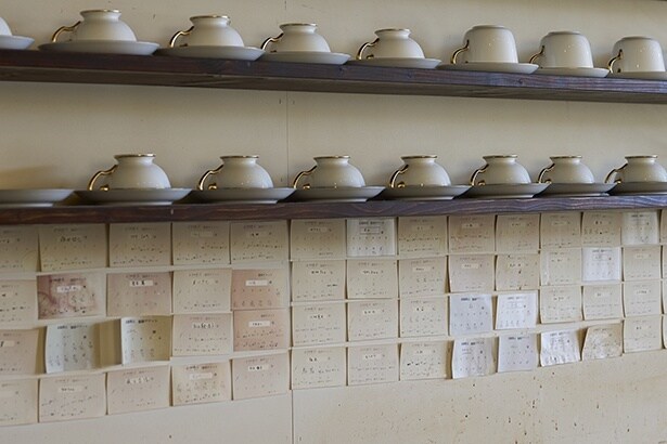 カウンターバックの壁は、ずらりと貼られたコーヒーチケットが一面に