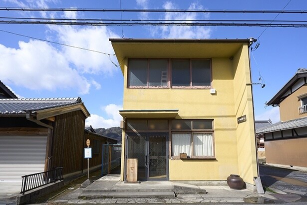 緑の山々を背景に、壁の黄色が映える店構え