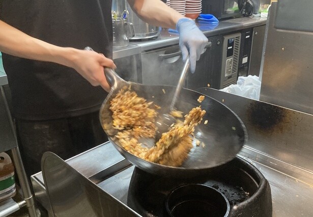 「黒しょうゆ」をしっかり絡める。背脂を乗せた「背脂黒ヤキメシ」(単品並910円、大1110円)もある