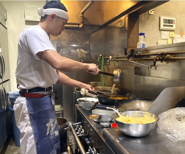 大将の本山敬也さん。中華鍋にスープ、具材を入れて一気に仕上げる、札幌由来の一体型製法