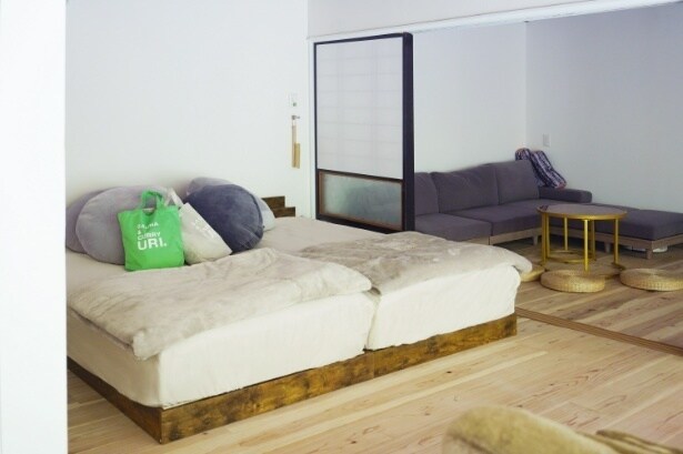 ふかふかのベッドと奥のソファでごろごろ過ごせる、プライベートサウナ旅にぴったりのくつろぎ空間