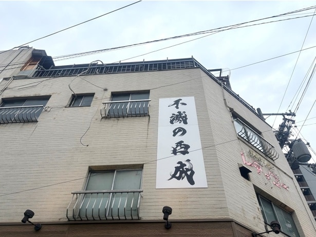 【写真】外壁に力強く掲げられた「不滅の西成」という文字