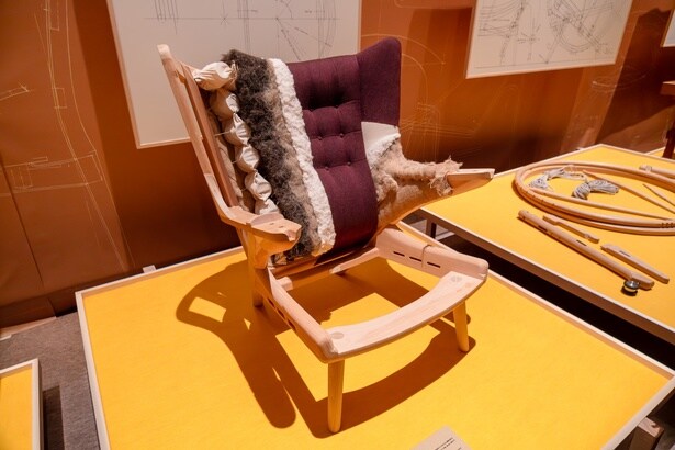 「パパベアチェア PP19 (1951年)」。完成までに少なくとも2週間を要する張りぐるみ椅子の代表作。英国のウイングバックチェアをもとに、自由な姿勢でくつろげる安楽椅子として再構築された。肘下を開放した構造が高い快適性を生み、座る人を包み込む姿から「パパベアチェア」と名づけられたという。現在はPPモブラー社が製作を担う。フレームと張地の構造から、コイルスプリングの上に、麻の繊維やヤシの茎、馬毛、綿などの伝統素材を重ね、職人の手の感覚によって形づくられていることがわかる