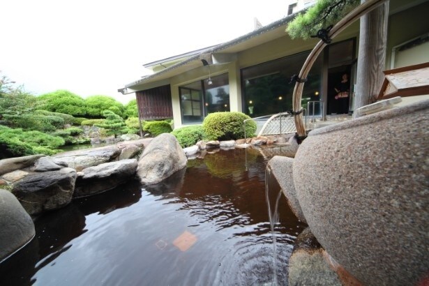 【写真】巨大な急須から露天風呂へお茶が注がれている