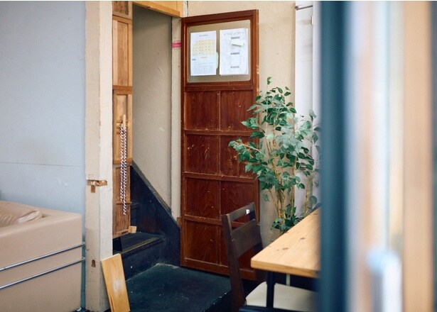 【写真】コインランドリー内の階段が入口。焙煎士との信頼関係を築き、訪れた人に最適な一杯をおすすめする「コーヒーの酒屋さん」のような店を目指している