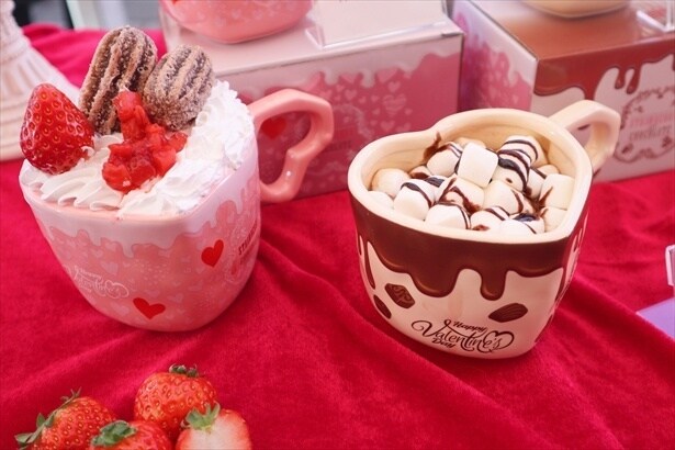 いちごミルクのチュロスパフェドリンク(写真左、単品1000円)とホットチョコレート(写真右、単品600円)　マグカップを持ち帰れるセット販売もある