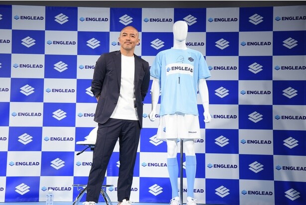 サインを書いたオリジナルのサッカーユニフォームを紹介する小野伸二さん