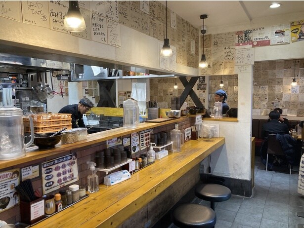 有名人のサインが壁にずらり。テーブル席もあり、複数人でも気軽に利用できる