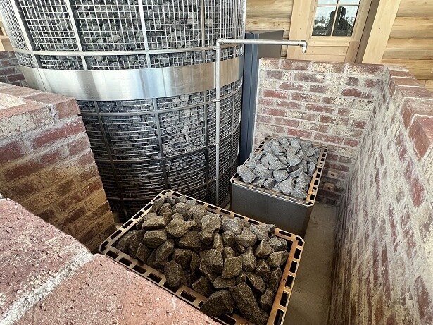 大きなサウナストーブの脇に熱源となるサウナストーブがある