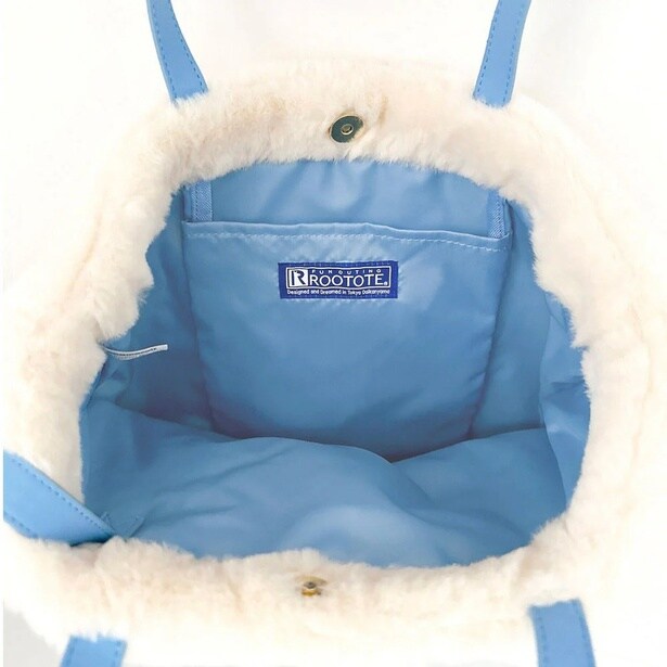 内側はブルーの裏地にポケット付き。口元はスナップボタンで留められるので中身が見える心配もない