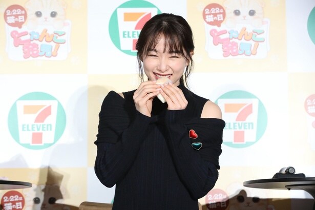 「三毛猫もちもちクレープ」を食べる桜井さん。「三毛猫もちもちクレープ」の価格(299円)は「肉球(ニクキュウ)」の語呂合わせになっている