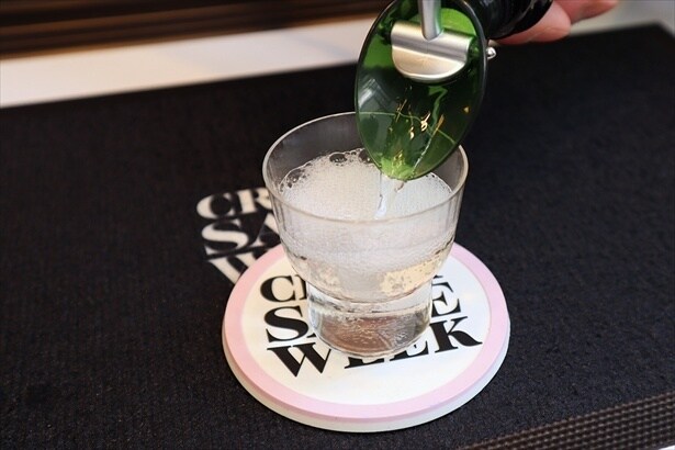 コインと交換でオリジナル酒器に日本酒が注がれる