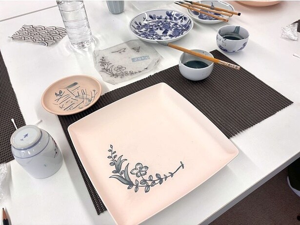 茶碗やお皿などの器を選んで、割れないように注意しながら藍色の絵具(呉須)で下絵付けを行う