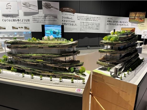 「ひらけ モン!展」で公開された精巧な建築模型。各フロアを緑が巡り、らせん状にうねる外装設計は、隈研吾さんがこの地の風景と文化からインスパイアされたもの