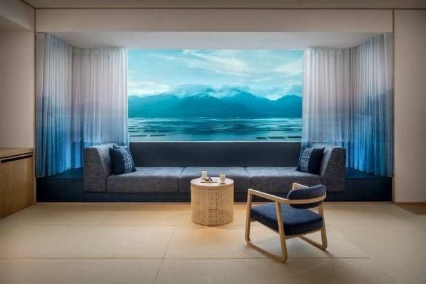 ご当地部屋「海霧の間」。瀬戸内海と島々が織り成す多島美を望む客室。柔らかなグラデーションで描かれたカーテンが、幻想的な海霧をイメージし、本物の景色とシームレスにつながる一体感を演出する