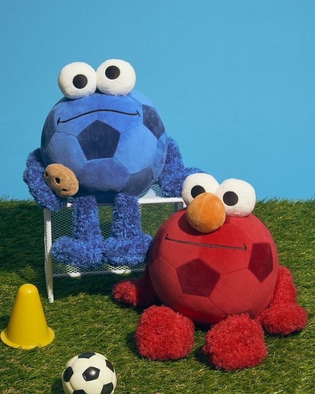 「サッカーボールなりきりぬいぐるみ」(全2種、各4950円)。写真左：ブルー(クッキーモンスター)、同右：レッド(エルモ)