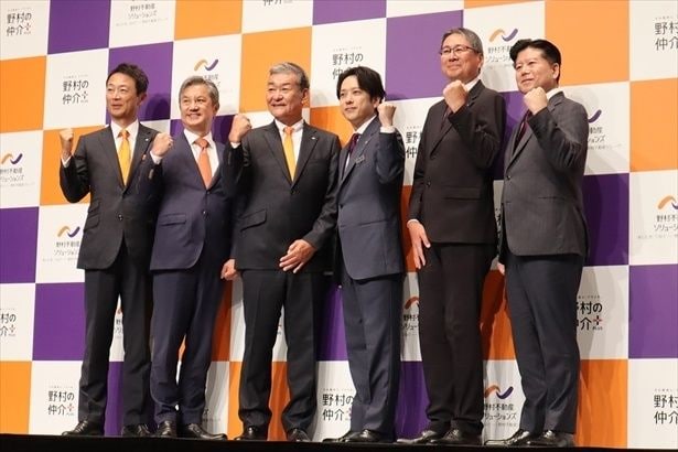 フォトセッションの様子。下手から井上泰博本部長、大野伸二本部長、日比野勇志社長、二宮和也さん、福地亨副社長、中村裕一本部長