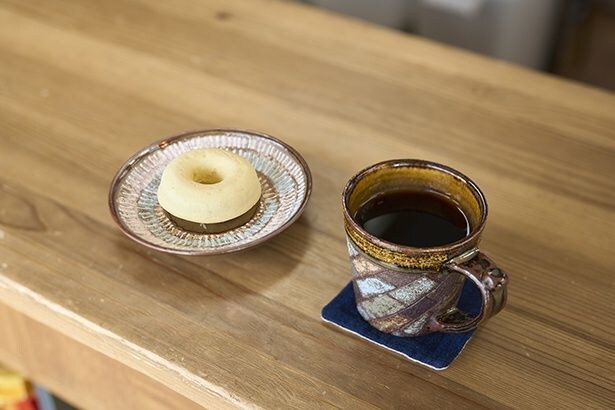 コーヒー560円~。カップは地元の作家・上田英二さんの作。自営米米粉の焼ドーナツは、プレーン270円、黒豆玄米・みかん・カカオ各320円の4種