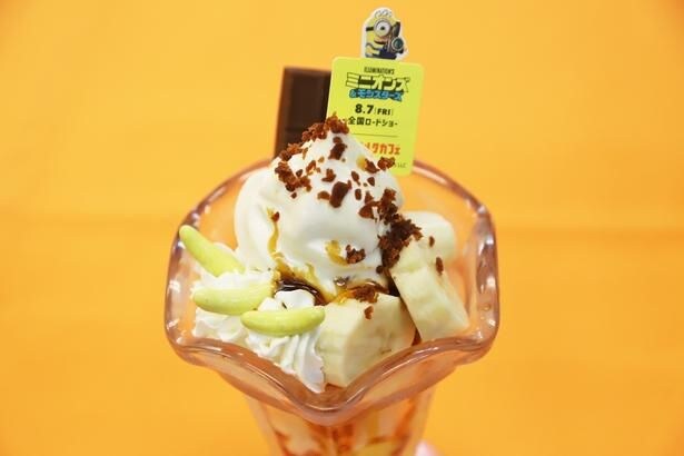ミニオンズのオリジナルピックを添えて提供される「ミニオンズ チョコっとゆかいなバナナパフェ コラボチャーム付き」(1200円)。パリパリ食感のバナナ形チョコレートがアクセントをプラス!