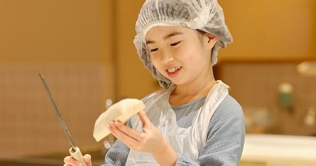 かまぼこ包丁で、すり身をなめらかに。子どもたちも真剣な表情に