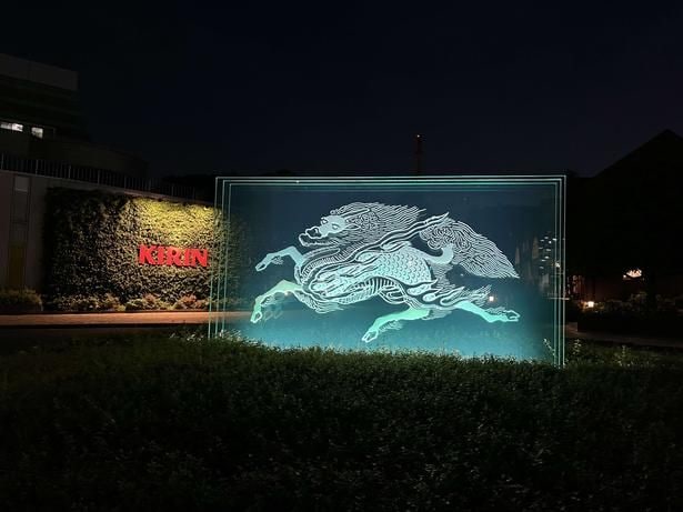 夜の工場敷地内に浮かび上がる幻想的な聖獣麒麟のライトアップ
