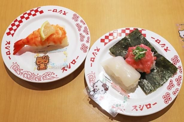 写真左から「第2弾 ハローキティ コラボクリアピック付き 大えび」(250円〜)、「第2弾 ハローキティ コラボクリアピック付き いか＋ねぎまぐろ包み」(250円〜) 