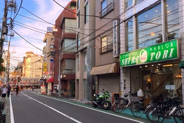 路面電車を望む『白鳥』の店先と街並み