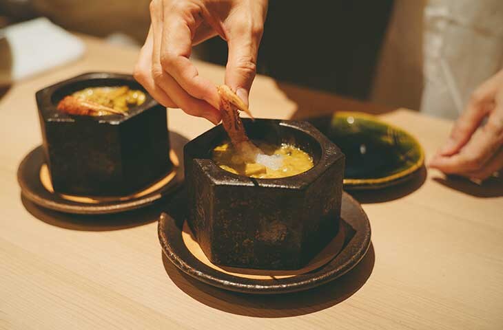 鮑肝ソースが絡む毛蟹と鮑の熱々御石