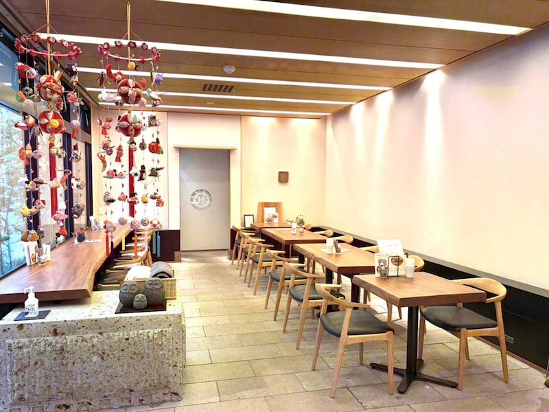 天然のオーク1枚板のテーブルと窓ガラスから差し込む太陽があたたかい雰囲気の店内