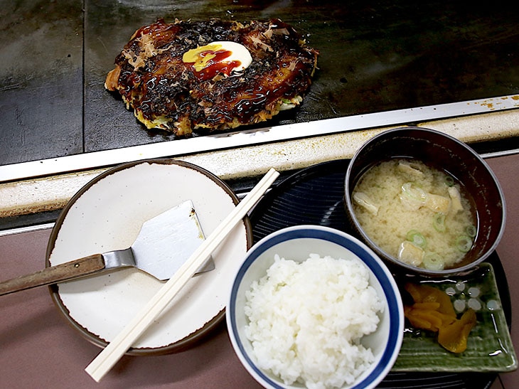 鉄板上のお好み焼きをおかずにいただく「豚玉定食」