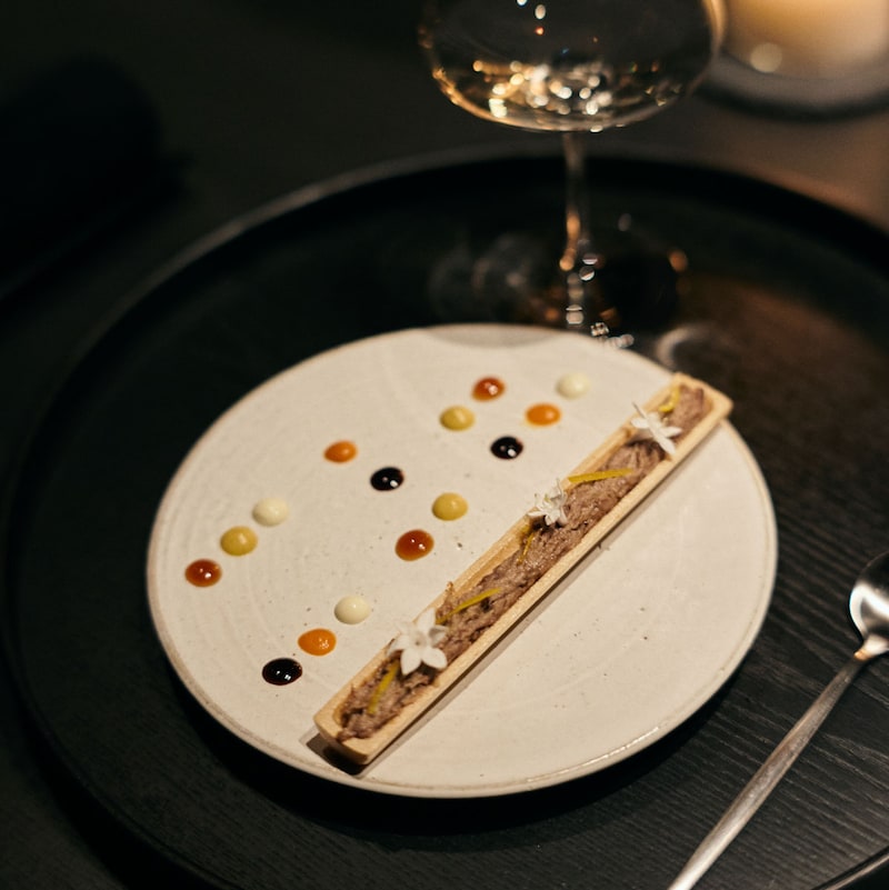 「視る」一皿。鴨のリエットは最中とともに。柚子の香りと白い花を添え、皿の上にはバルサミコや豆腐、味噌、人参など5種類のソースをドット状に配置。味の組み合わせを探りながら食べ進める楽しさがあります