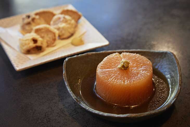 手前：「鴨だし煮大根」1,000円。鴨肉の出汁が芯までしみた一品。奥：「鳥だんご」1,000円